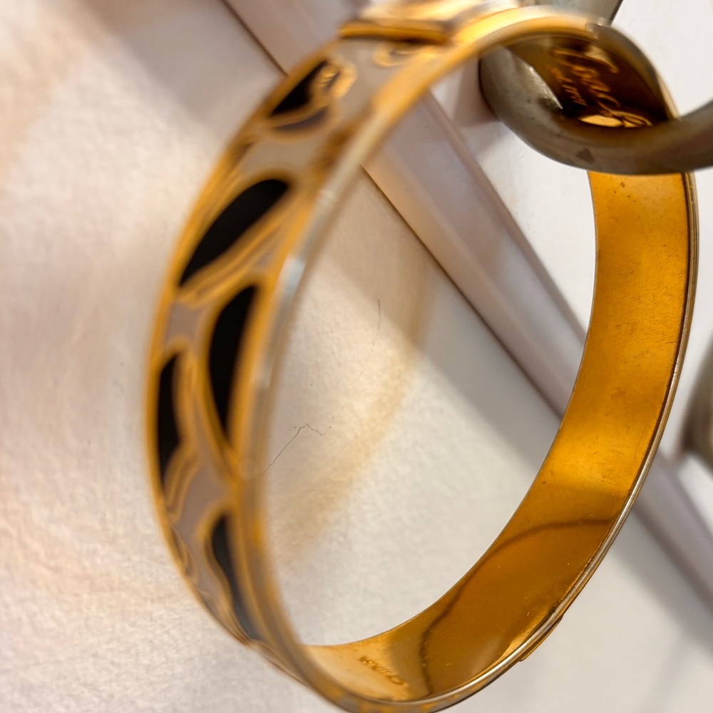 Ladies COACH bangle bracelet.Gold laminate w/ bl & white design.